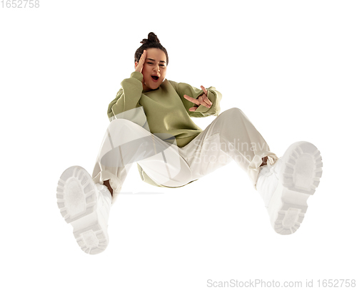 Image of Young stylish woman in modern street style outfit isolated on white background, shot from the bottom