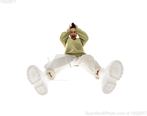 Image of Young stylish woman in modern street style outfit isolated on white background, shot from the bottom