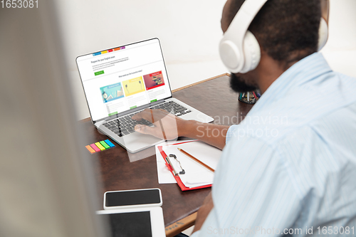 Image of Online english courses at home. Close up hands of man during teaching students remotely in interior of living room