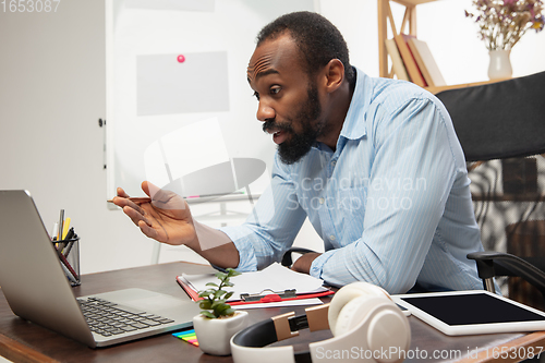 Image of Online english courses at home. Smiling man teaches students remotely in interior of living room