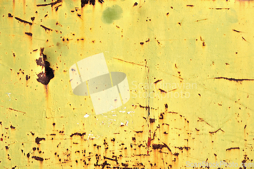 Image of chipped yellow paint on rusty iron