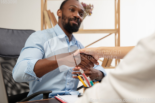 Image of English courses at home. Smiling man teaches student in interior of living room