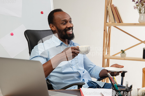 Image of Online english courses at home. Smiling man teaches students remotely in interior of living room