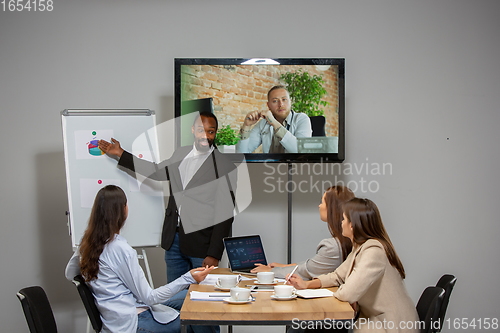 Image of Young people talking, working during videoconference with colleagues at office or living room