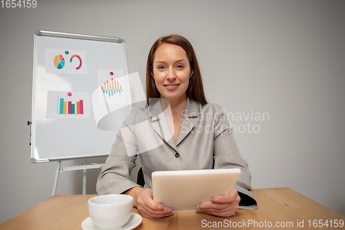 Image of Young woman talking, working during videoconference with colleagues at home office