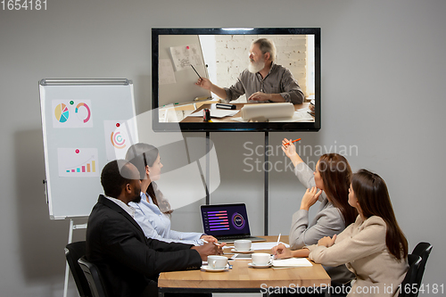 Image of Young people talking, working during videoconference with colleagues at office or living room