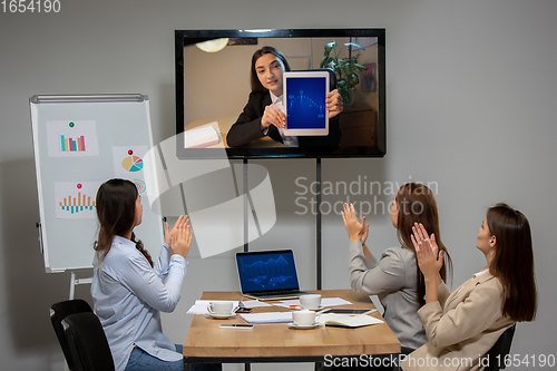 Image of Young women talking, working during videoconference with colleagues at office or living room