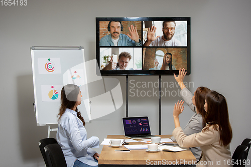 Image of Young women talking, working during videoconference with colleagues at office or living room