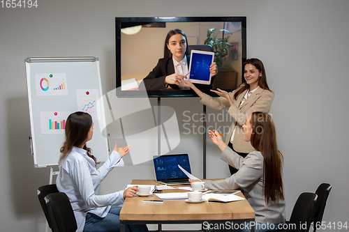 Image of Young women talking, working during videoconference with colleagues at office or living room