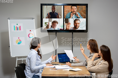 Image of Young women talking, working during videoconference with colleagues at office or living room