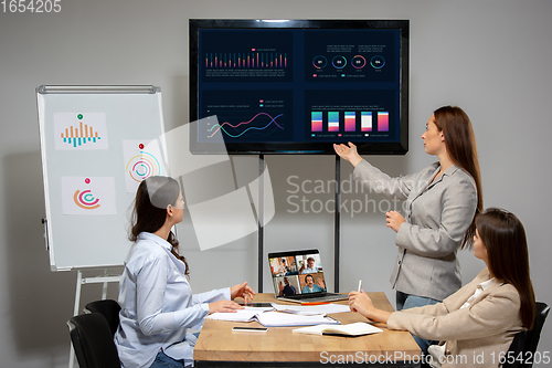 Image of Young women talking, working during videoconference with colleagues at office or living room