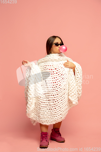 Image of Caucasian female inclusive model posing on pink studio background in stylish outfit