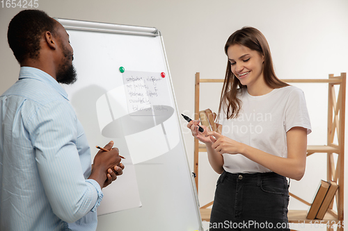 Image of English courses at home. Smiling man teaches student in interior of living room