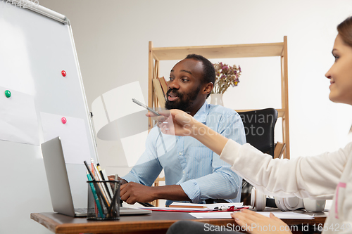 Image of English courses at home. Smiling man teaches student in interior of living room