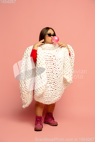 Image of Caucasian female inclusive model posing on pink studio background in stylish outfit