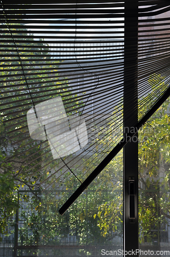 Image of crooked blinds and sunlight on dusty window