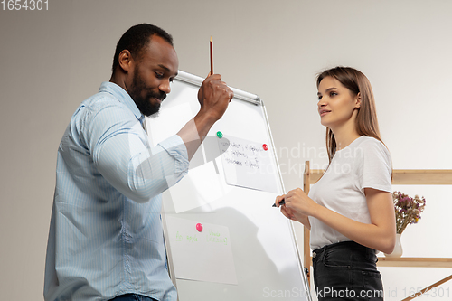 Image of English courses at home. Smiling man teaches student in interior of living room