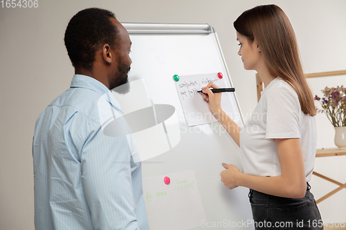 Image of English courses at home. Smiling man teaches student in interior of living room