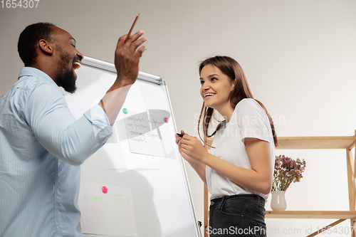 Image of English courses at home. Smiling man teaches student in interior of living room