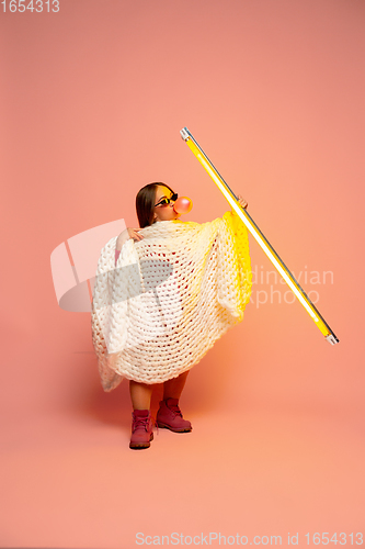 Image of Caucasian female inclusive model posing on pink studio background in stylish outfit