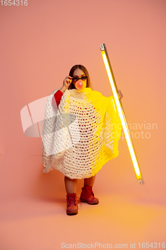 Image of Caucasian female inclusive model posing on pink studio background in stylish outfit