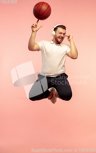 Image of Full length portrait of young successfull high jumping man gesturing isolated on pink studio background