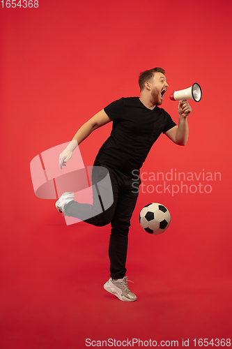 Image of Full length portrait of young successfull jumping man gesturing isolated on red studio background