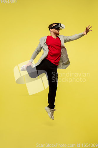 Image of Full length portrait of young successfull high jumping man gesturing isolated on yellow studio background