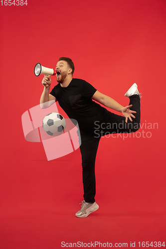 Image of Full length portrait of young successfull jumping man gesturing isolated on red studio background