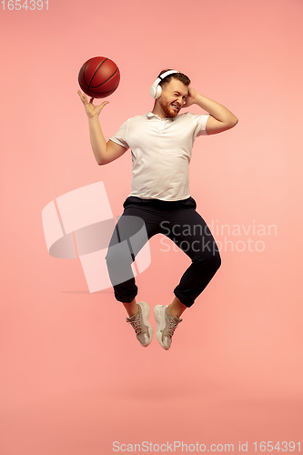 Image of Full length portrait of young successfull high jumping man gesturing isolated on pink studio background