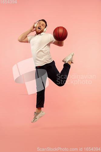 Image of Full length portrait of young successfull high jumping man gesturing isolated on pink studio background