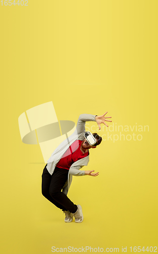 Image of Full length portrait of young successfull high jumping man gesturing isolated on yellow studio background