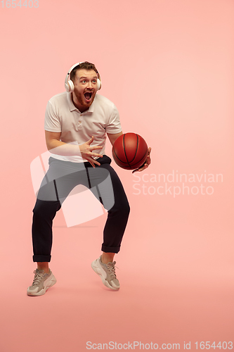 Image of Full length portrait of young successfull high jumping man gesturing isolated on pink studio background