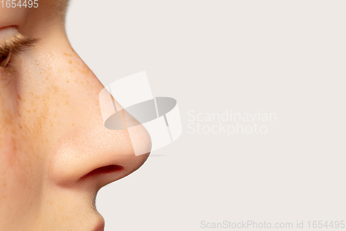 Image of Close up portrait of beautiful redhair caucasian girl isolated on studio background. Beauty, fashion, skincare, cosmetics concept. Details.