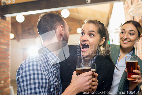 Image of Happy co-workers celebrating corporate event after tensioned work day. Look delighted, friendly, cheerful