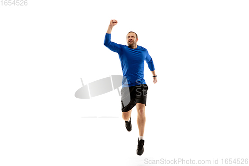 Image of Caucasian professional runner, jogger training isolated on white studio background in fire