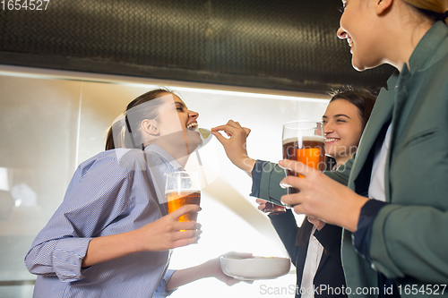 Image of Happy co-workers celebrating corporate event after tensioned work day. Look delighted, friendly, cheerful