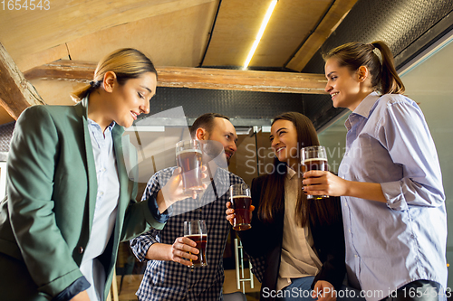 Image of Happy co-workers celebrating corporate event after tensioned work day. Look delighted, friendly, cheerful