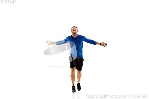 Image of Caucasian professional runner, jogger training isolated on white studio background in fire