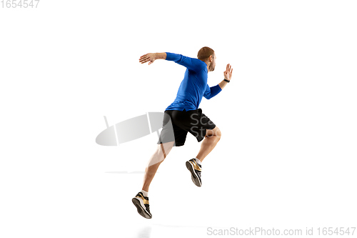 Image of Caucasian professional runner, jogger training isolated on white studio background in fire