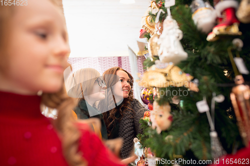 Image of Smiling family, mother and kids looking for home decoration and holiday\'s gifts in household store