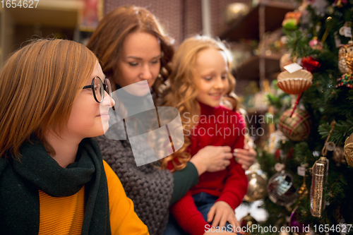 Image of Smiling family, mother and kids looking for home decoration and holiday\'s gifts in household store