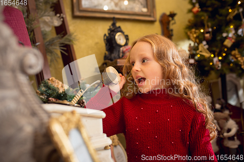 Image of Cheerful little girl looking for home decoration and holiday\'s gifts in household store