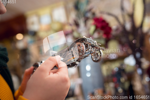 Image of Cheerful little boy looking for home decoration and holiday\'s gifts in household store