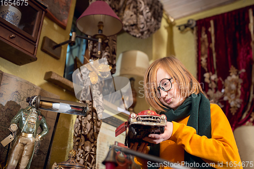 Image of Cheerful little boy looking for home decoration and holiday\'s gifts in household store