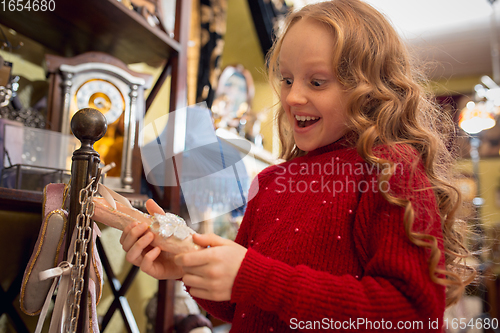 Image of Cheerful little girl looking for home decoration and holiday\'s gifts in household store