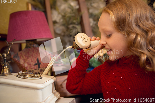 Image of Cheerful little girl looking for home decoration and holiday\'s gifts in household store