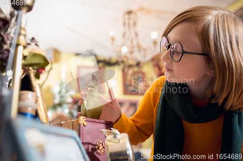 Image of Cheerful little boy looking for home decoration and holiday\'s gifts in household store