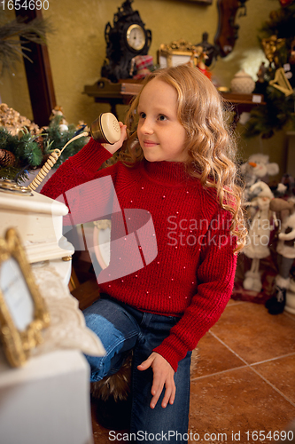 Image of Cheerful little girl looking for home decoration and holiday\'s gifts in household store