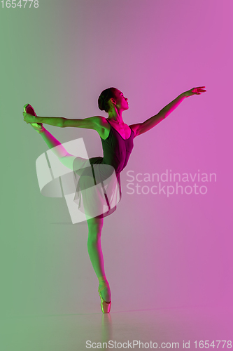 Image of Young and graceful ballet dancer isolated on gradient pink-green studio background in neon light. Art in motion